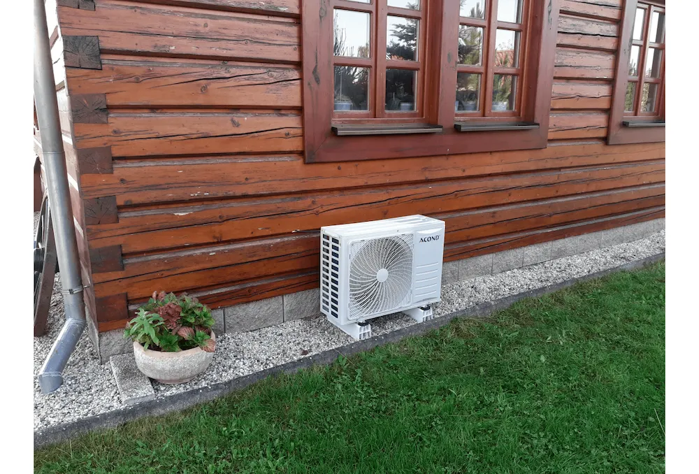 Venkovní jednotka klimatizace Acond na stěně dřevěné roubenky