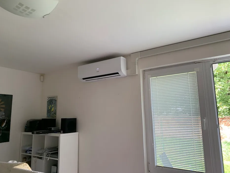 Nástěnná klimatizace namontovaná v obytném pokoji s obrazy